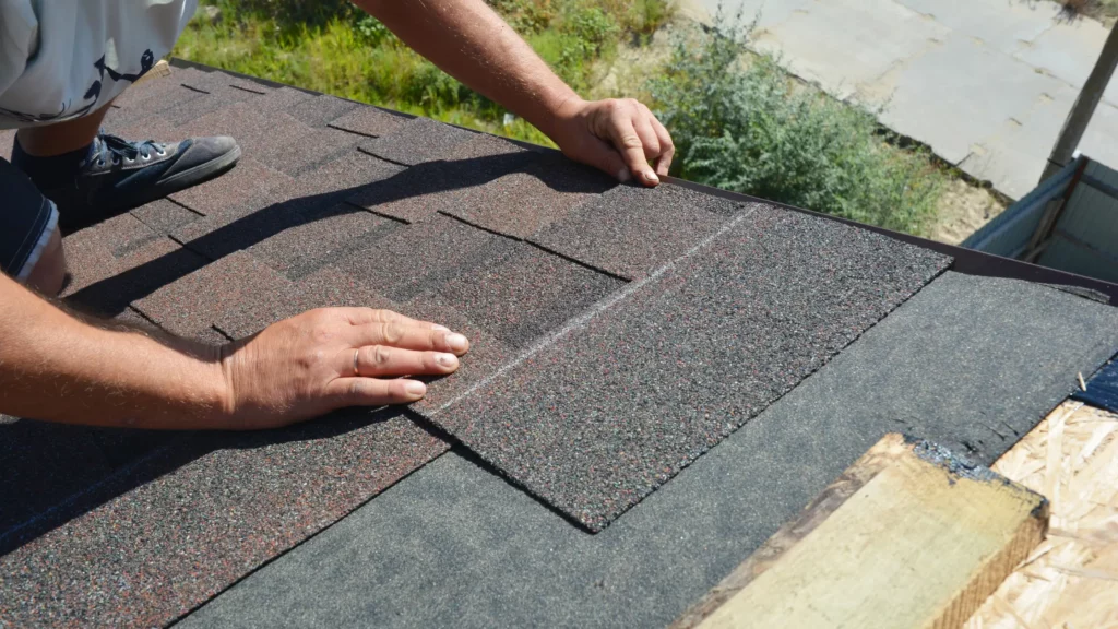 man placing tile on roof