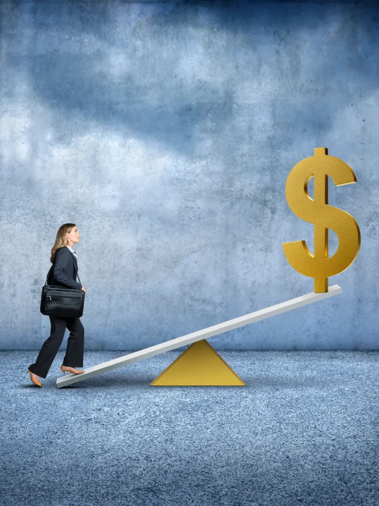 A woman in business attire with a black shoulder bag walks up a seesaw towards a large, golden dollar sign at the higher end, set against a textured blue-grey background.