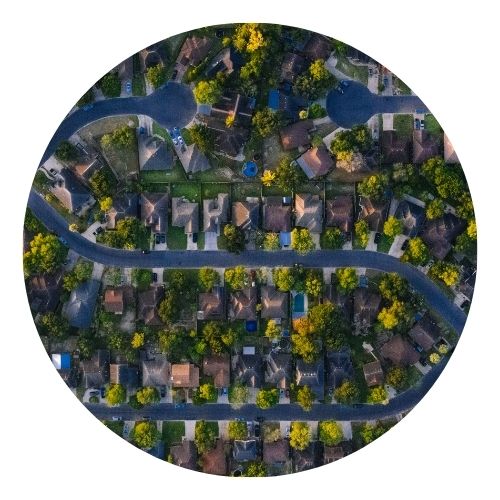 Aerial view of a suburban neighborhood with curving streets and trees.
