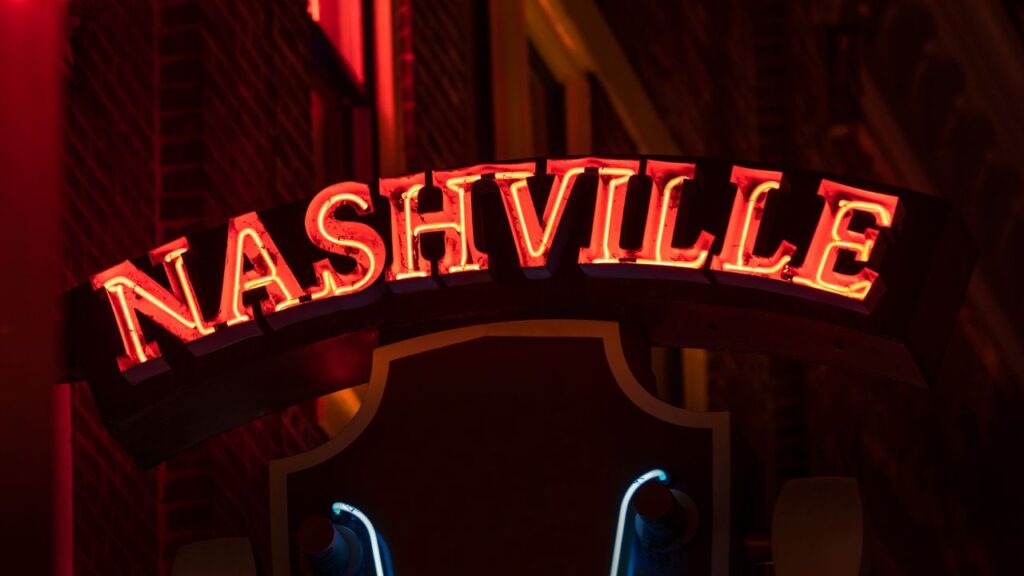 A red neon sign that says “Nashville” lit up at night.
