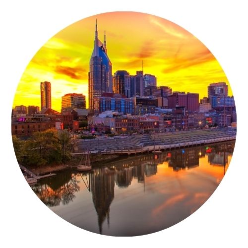 City skyline at sunset reflected in a river.