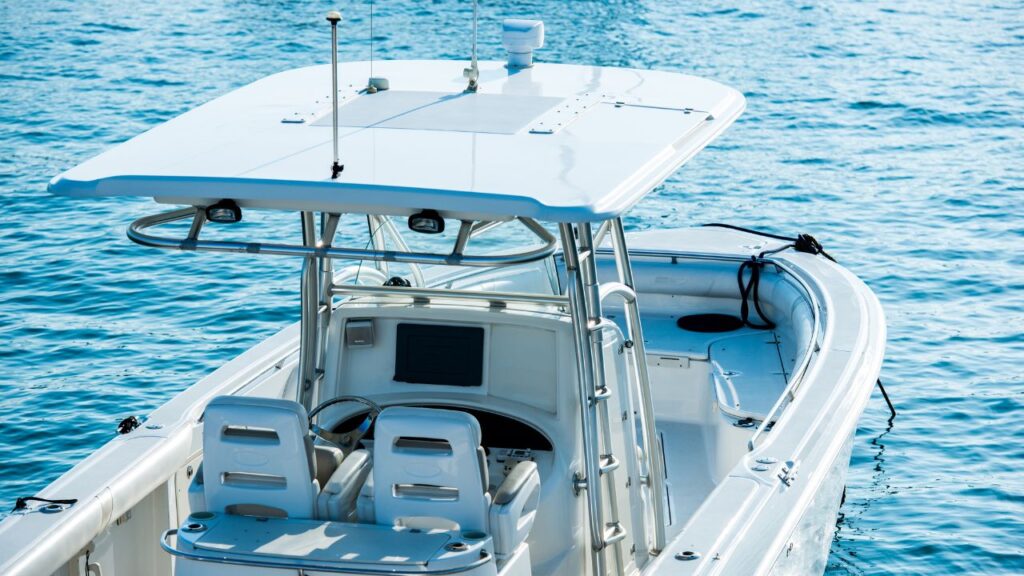 A white center console boat floating on clear blue water.