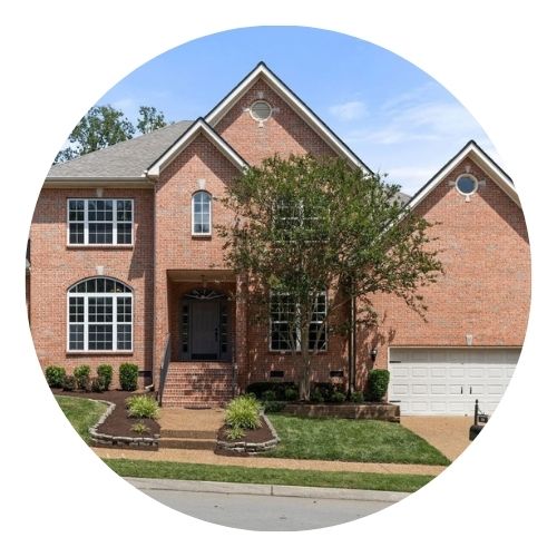 Two-story brick home with a front-facing garage and arched windows.