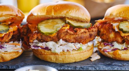 Fried chicken sandwiches with pickles and coleslaw on brioche buns.