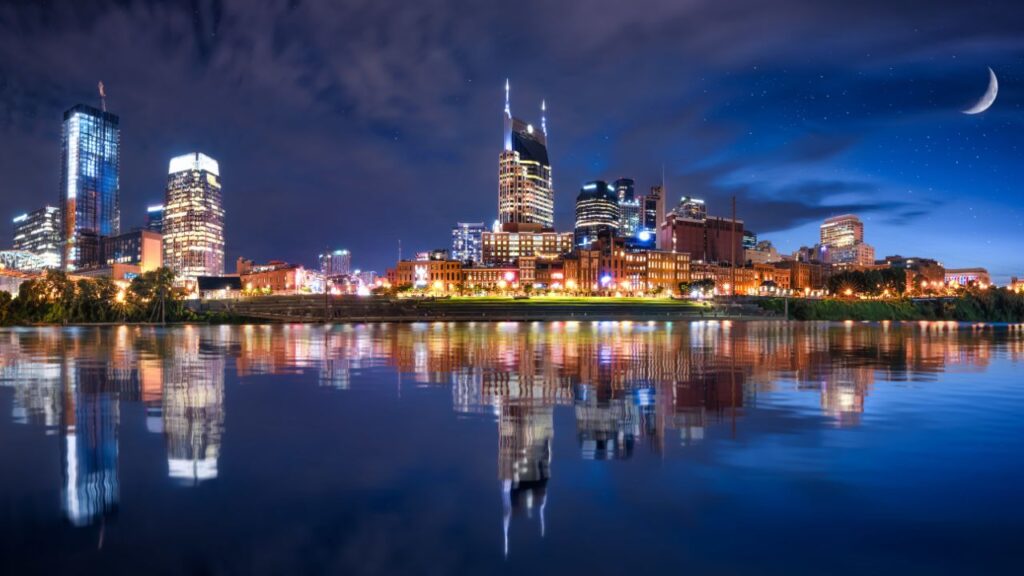 Nashville city skyline at night reflecting on the water.