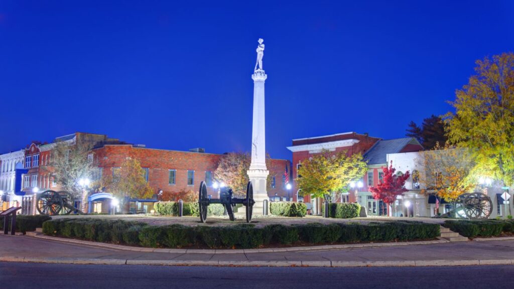 Franklin's town square with a tall monument surrounded by historic buildings at dusk.