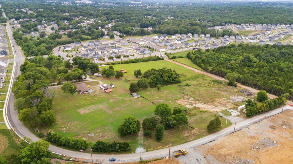 Aerial view of a large open property bordered by trees and a suburban neighborhood in Antioch, Tennessee.
