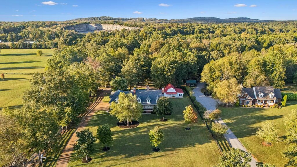 Aerial view of a rural home with trees and open fields in Murfreesboro, Tennessee.