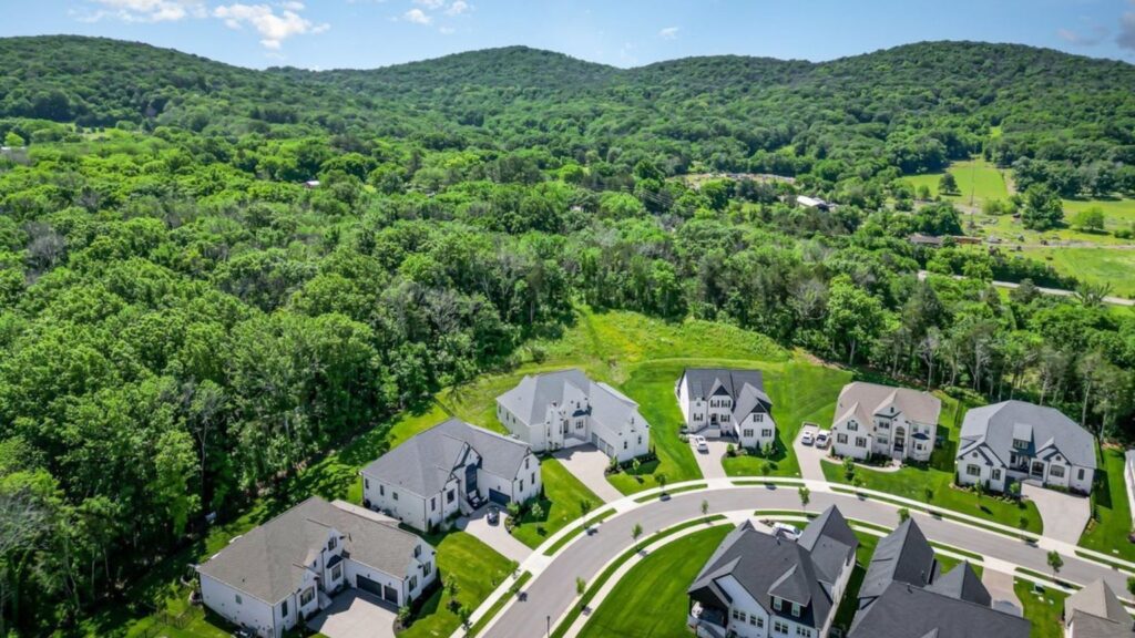 Aerial view of a residential neighborhood backed by wooded hills in Nolensville, Tennessee.