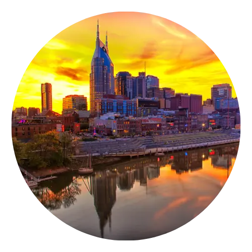Nashville city skyline with dramatic orange sunset sky reflected in the Cumberland River.
